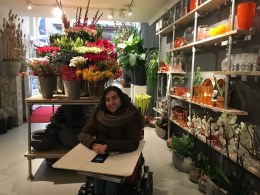 Afbeelding meisje in elektrische rolstoel in bloemenwinkel