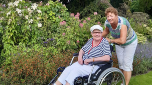 afbeelding 2 dames waarvan 1 in een rolstoel samen op pad