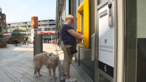 afbeelding Ellen Zieleman bij sprekende geldautomaat met hulphond