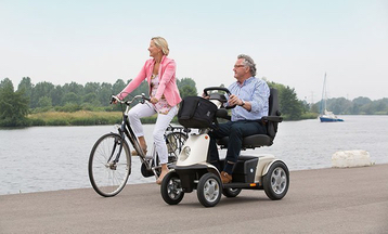 afbeelding man in scootmobiel en vrouw op fiets
