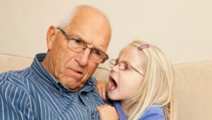 afbeelding oude man met gehoorverlies en jong meisje