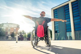 man in rolstoel armen gespreid het leven toejuichend